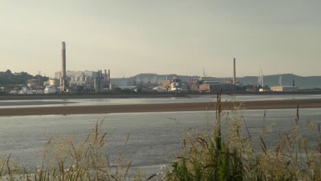 Looking-across-river-Mersey-estuary-to-Runcorn-industrial-chemical-waterfront-factory-businesses-at-sunrise