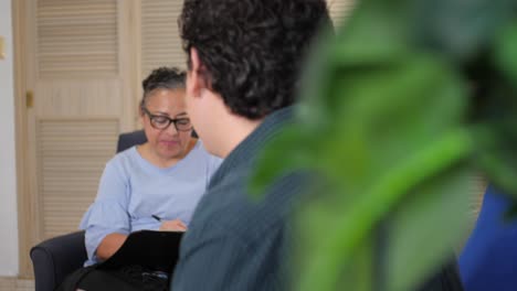 Latina-Psychologist-Listens-to-Patient-and-Takes-Notes-in-Office