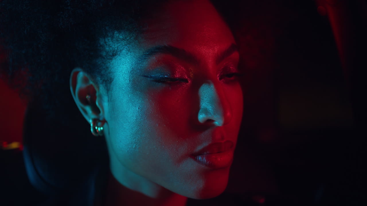 Relaxed car passenger riding at night city illuminated neon lights closeup