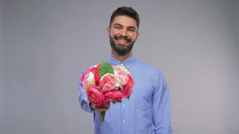 Feliz-Joven-Sonriente-Con-Ramo-De-Flores.-Día-De-San-Valentín,-Saludo-Y-Concepto-De-Vacaciones:-Retrato-En-Video-De-Un-Joven-Feliz-Y-Sonriente-Con-Un-Ramo-De-Flores-Sobre-Fondo-Gris