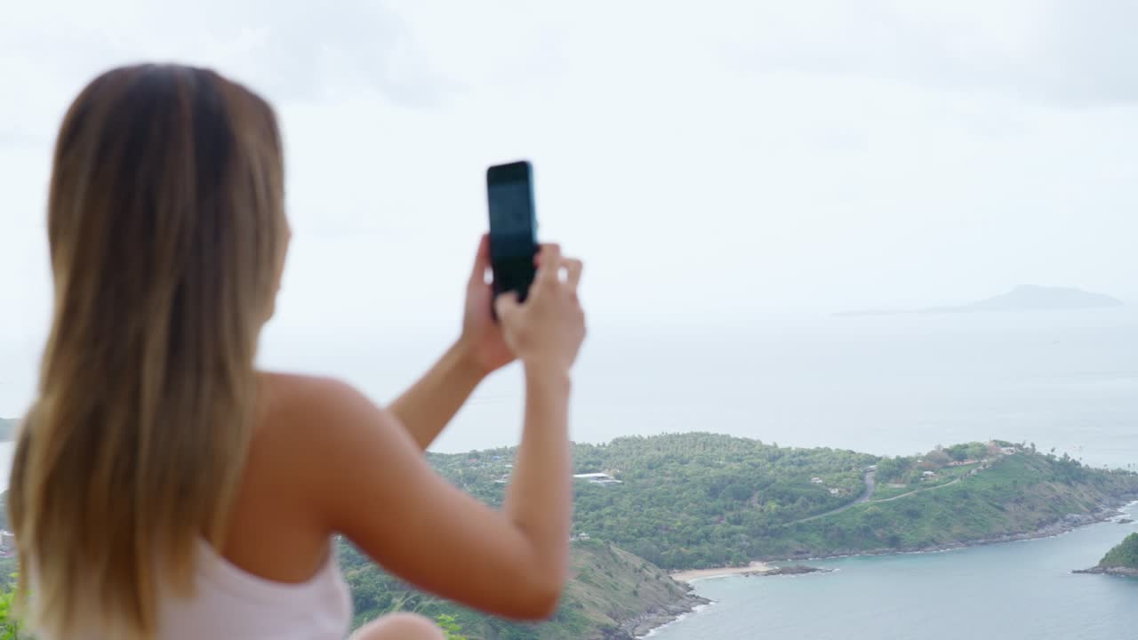 4K Young Asian woman using mobile phone photography beautiful sea while travel at tropical island