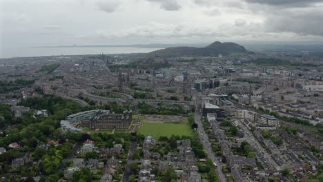 scenic drone aerial footage of edinburgh with salisbury crags on arthurs seat in background, scotland