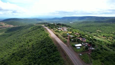 aerial view road cutting through hills and fields in nature of africa