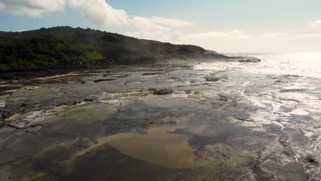 Aerial-drone-shot-of-rocky-reef-coastline-bush-headland-Catherine-Hill-Bay-Newcastle-tourism-NSW-Australia-4K