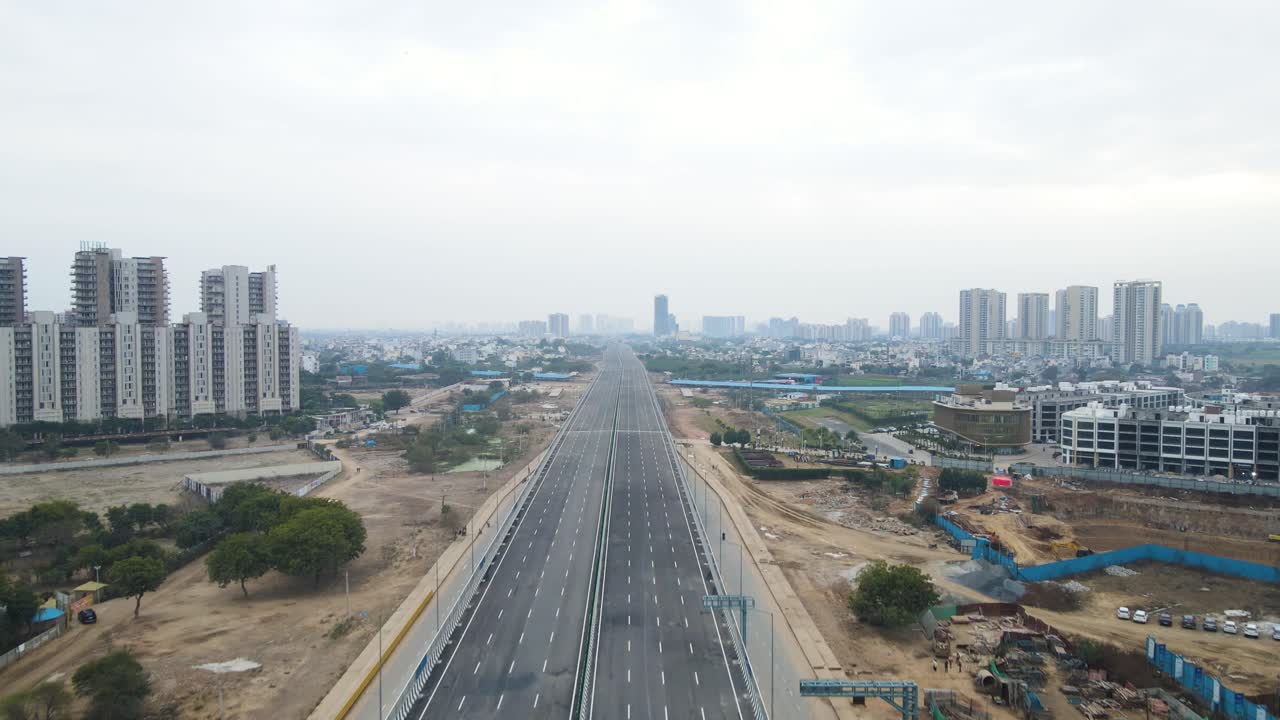 Aerial drone shot capturing the progress of a large real estate project near Dwarka Expressway, with heavy construction equipment in action.
