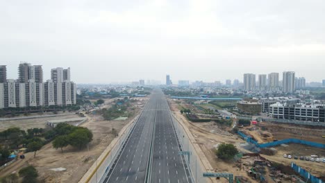 aerial drone shot capturing the progress of a large real estate project near dwarka expressway, with heavy construction equipment in action.