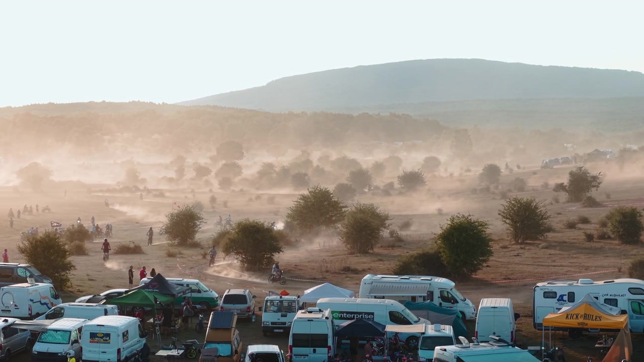 Motocross Riders Racing on Dusty Off-Road Track at Sunset