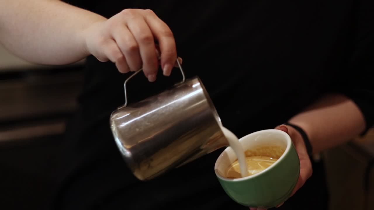 커피 컵 에 우유 를 부는 바리스타