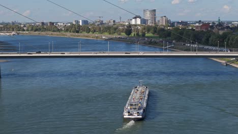 Cargo-ship-tanker-transporting-gas-under-the-bridge-in-Dusseldorf-city,-Germany
