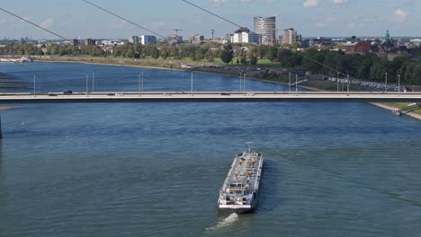 cargo ship tanker transporting gas under the bridge in dusseldorf city, germany