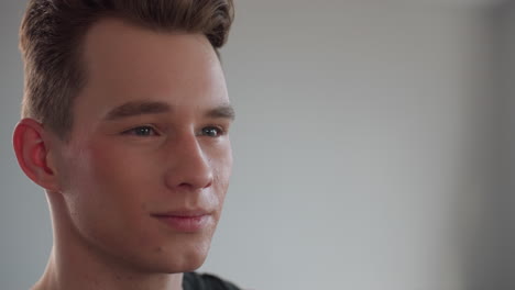 close up of man styling hair with both hands before mirror capturing moment of satisfaction, natural light accentuating hair texture and skin tone in bright minimalist studio interior