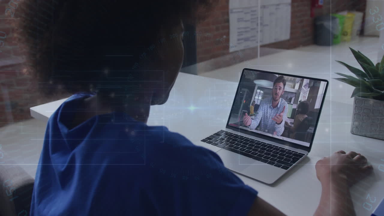 Watching animation on laptop, person in blue shirt during video call at home