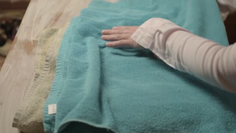 woman folding towels after doing the laundry