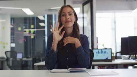 Caucasian-businesswoman-sitting-at-desk-having-video-call