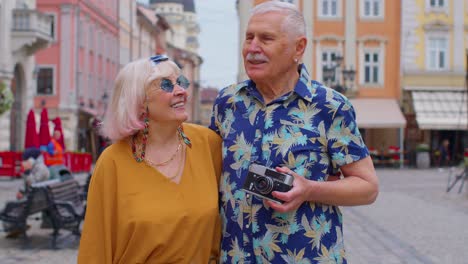 senior old stylish tourists man, woman, grandmother, grandfather family having a walk in summer city