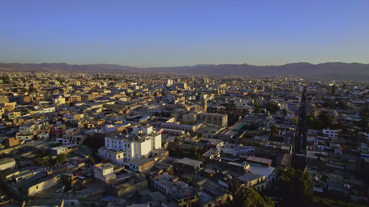 Vista Aerea di una Città con Montagne sullo Sfondo all'Ora d'Oro