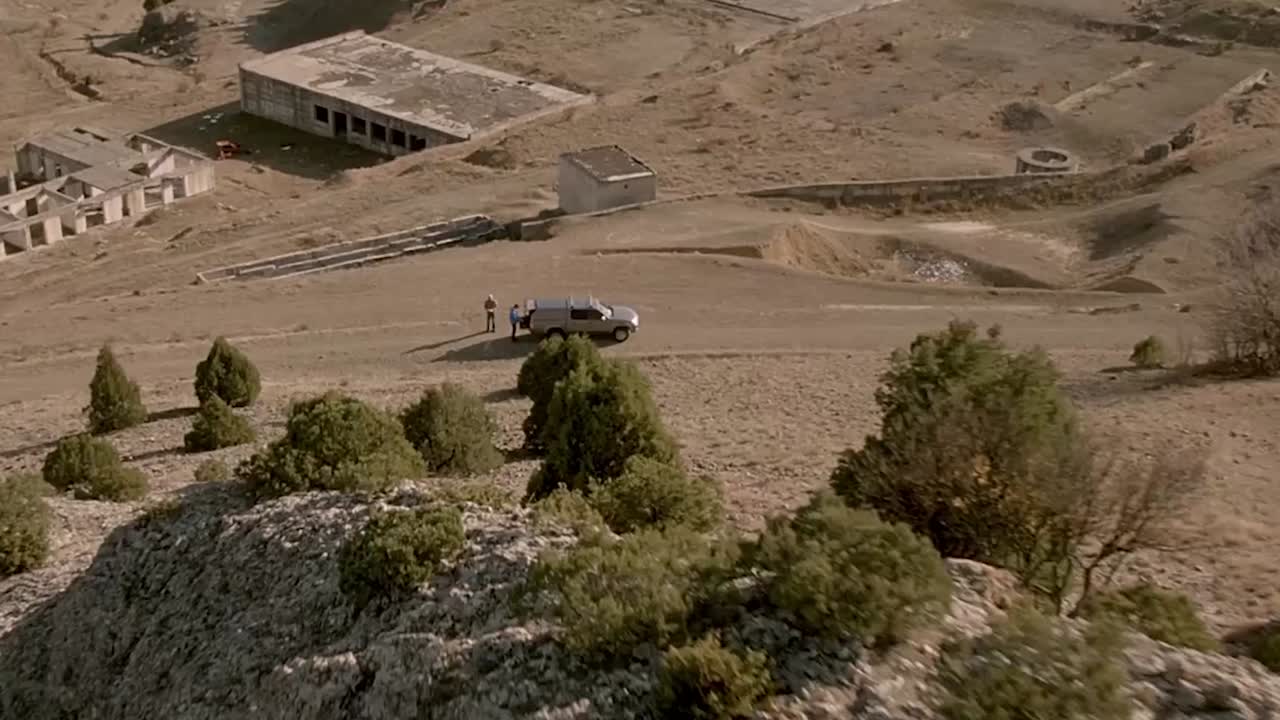 vista aérea de una zona abandonada con personas y vehículos