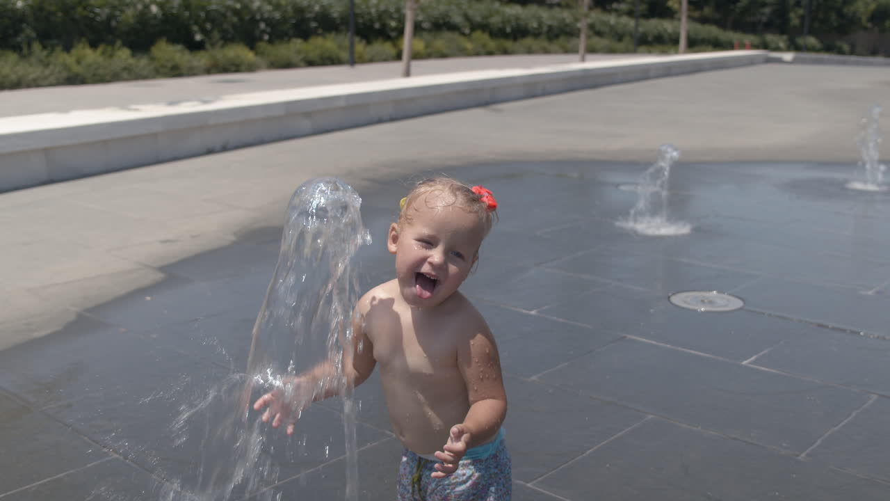 작은 아이가 분수 제트와 함께 재미를
