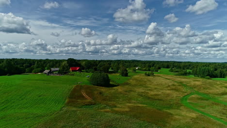 Antena-Mágica-De-Una-Granja-Verde-Y-Exuberante-Con-Las-Nubes-Más-Esponjosas-Que-Jamás-Hayas-Visto-En-El-Cielo