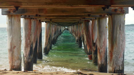 slow motion perspective view underneath old wooden jetty