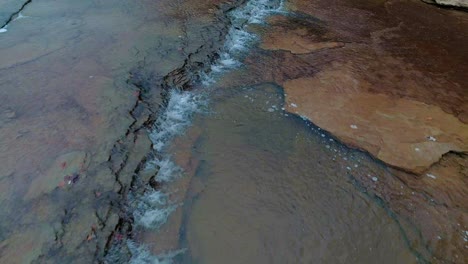 Aerial-revers-flying-dolly-shot-over-peaceful-waterfall-on-Cedar-Creek-in-Monterey-Kentucky-beautiful-colorful-rocks