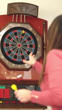 group of multi-ethnic friends playing darts at home