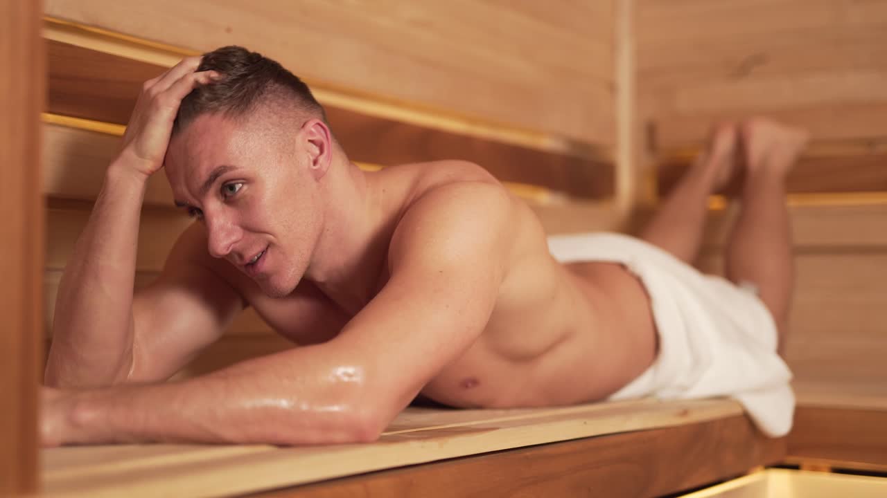 Un uomo sportivo e affascinante si rilassa nella sauna russa.