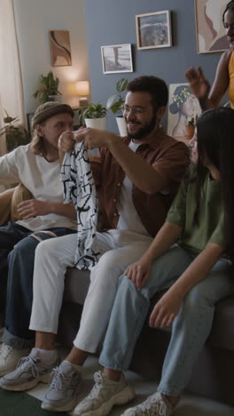 friends showing a new patterned shirt in the living room