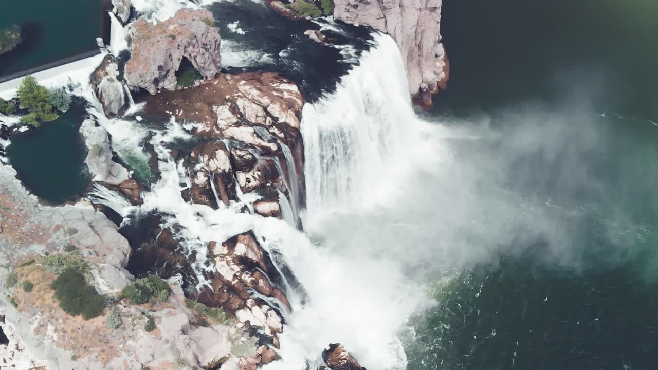 inclinación aérea hacia arriba en cámara lenta de las cataratas shoshone que expulsan una nube de niebla en el río snake en twin falls, idaho