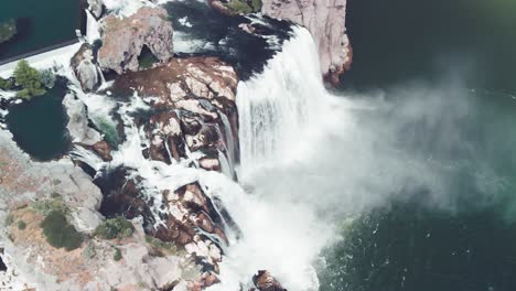 slow motion upward aerial tilt of shoshone falls expelling a cloud of mist into the snake river in twin falls, idaho