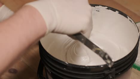 a worker open bucket the paint for painting the walls