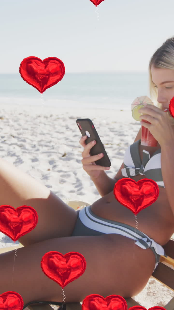animación de iconos digitales de corazón sobre una mujer en silla de sol usando un teléfono inteligente en la playa