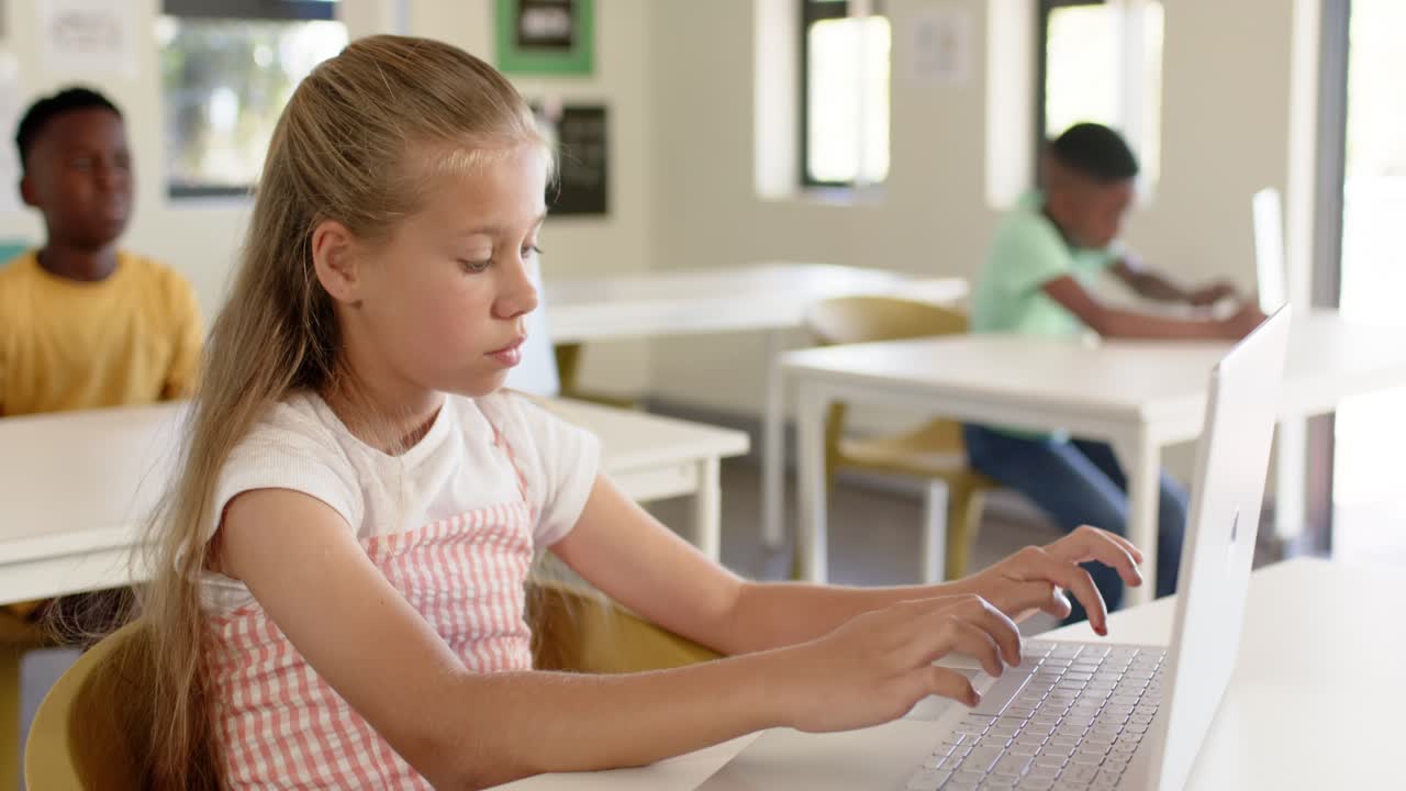 Giovane studentessa si protende, esitando, digita sul laptop in classe per terminare il lavoro.