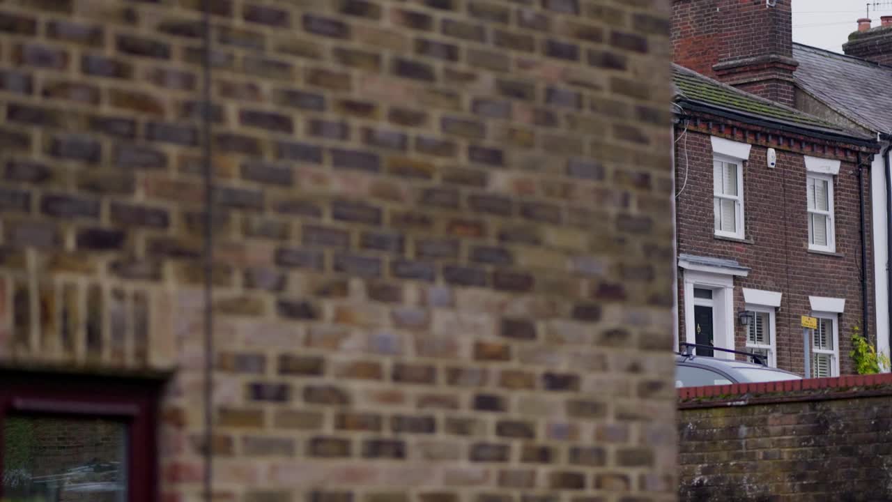 Close-up of a brick wall, then shifting to reveal rows of houses in Hemel Hempstead at different angles