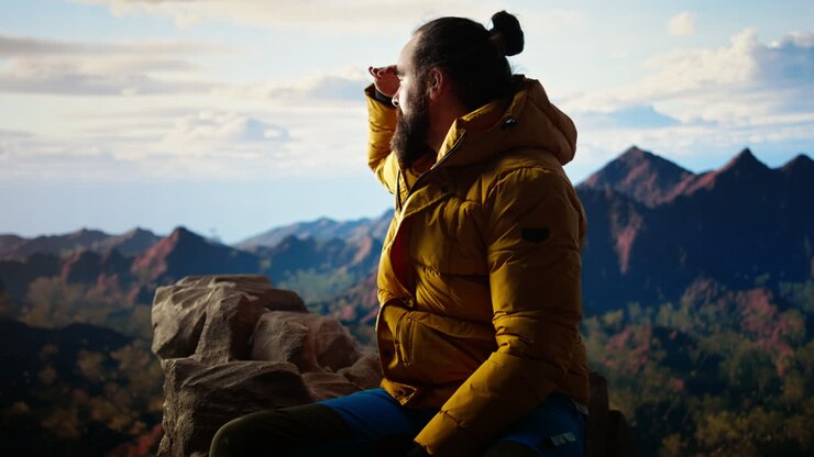 Victorious hiker relaxing at the mountain summit after climbing the top