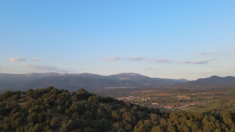 Sonnenuntergangsflug-Mit-Einer-Drohne-Zur-Entdeckung-Eines-Tals-Mit-Zwei-Städten-In-Sichtweite-Und-Einem-Hintergrund-Aus-Bergen