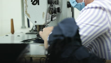 A-Sew-Factory-Worker-Sewing-Blue-Face-Masks---Covid-19-Pandemic---Medium-Shot