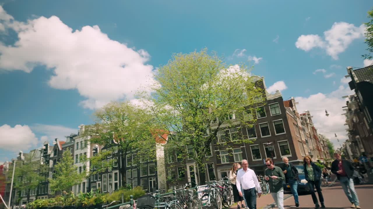 Amsterdam canal cityscape with pedestrians and bicycles