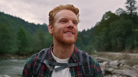 excited man enjoying hike along river