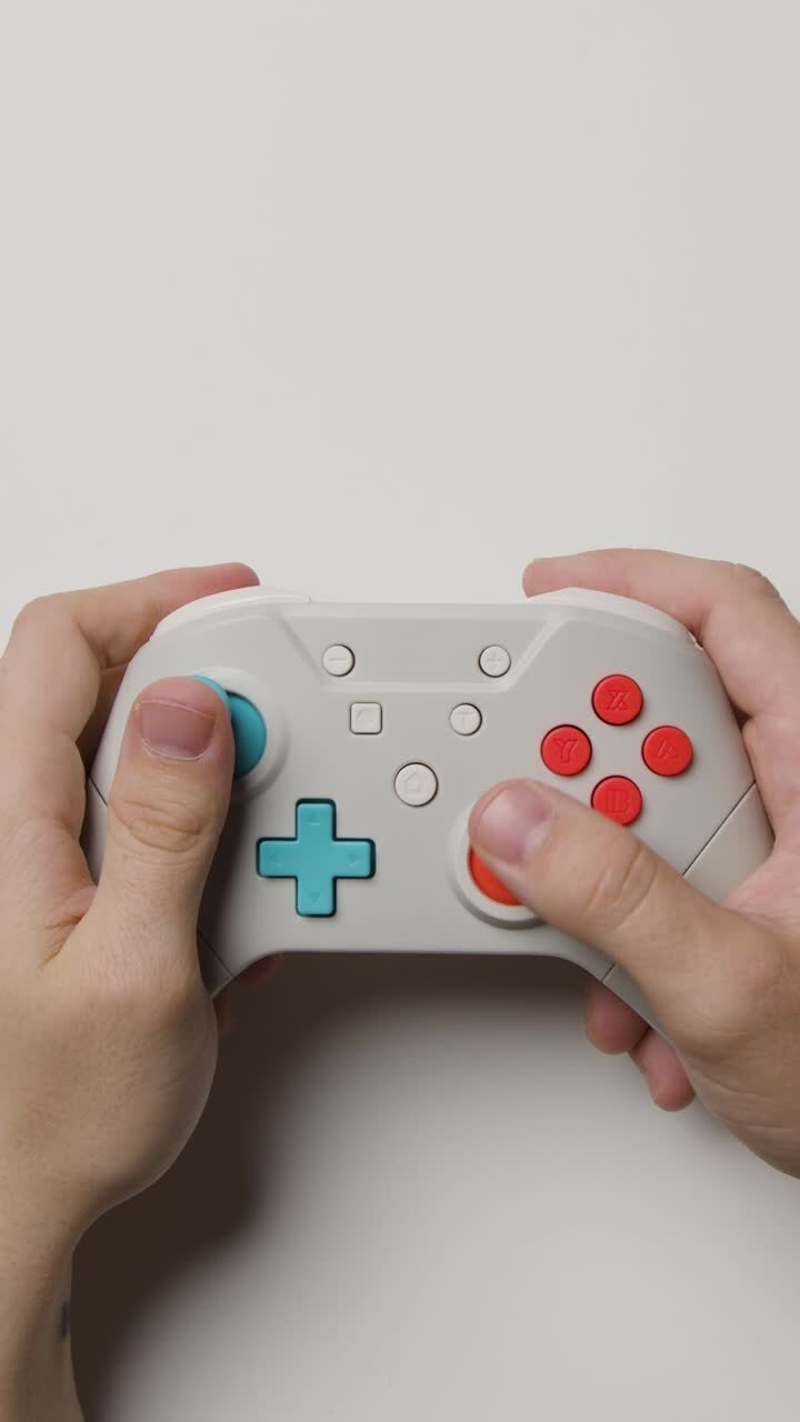 Video verticale: mani in studio riprese dall'alto che usano un controller per videogiochi