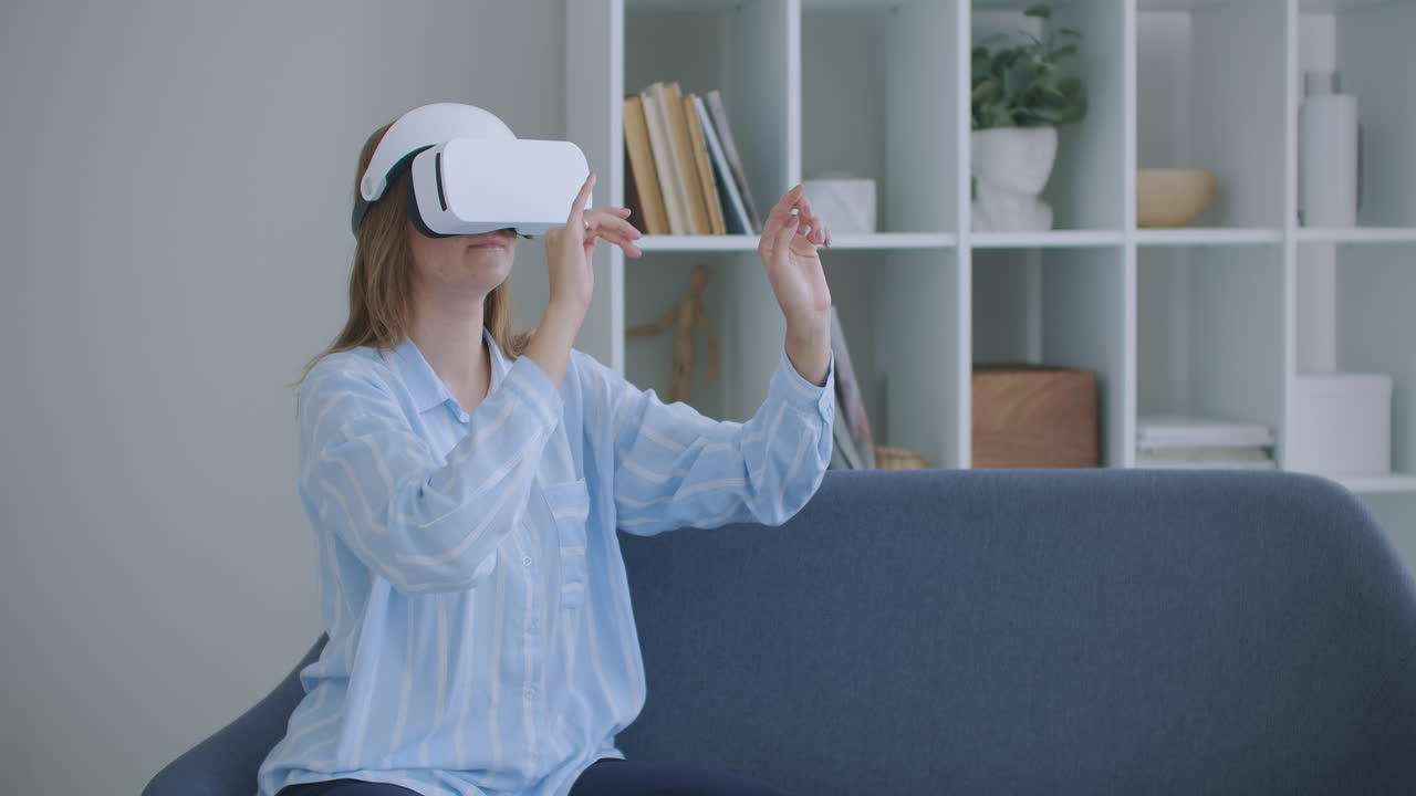 chica joven en auriculares de realidad virtual desplazándose por el aire en el concepto de tecnología en el hogar. mujer joven alegre con auriculares de realidad virtual viendo una película de video 360 vr sentada en la cama en casa.