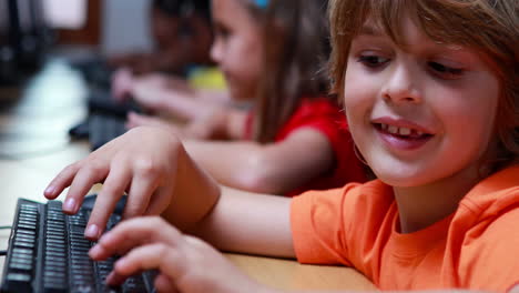 Little boy smiling at camera during computer class