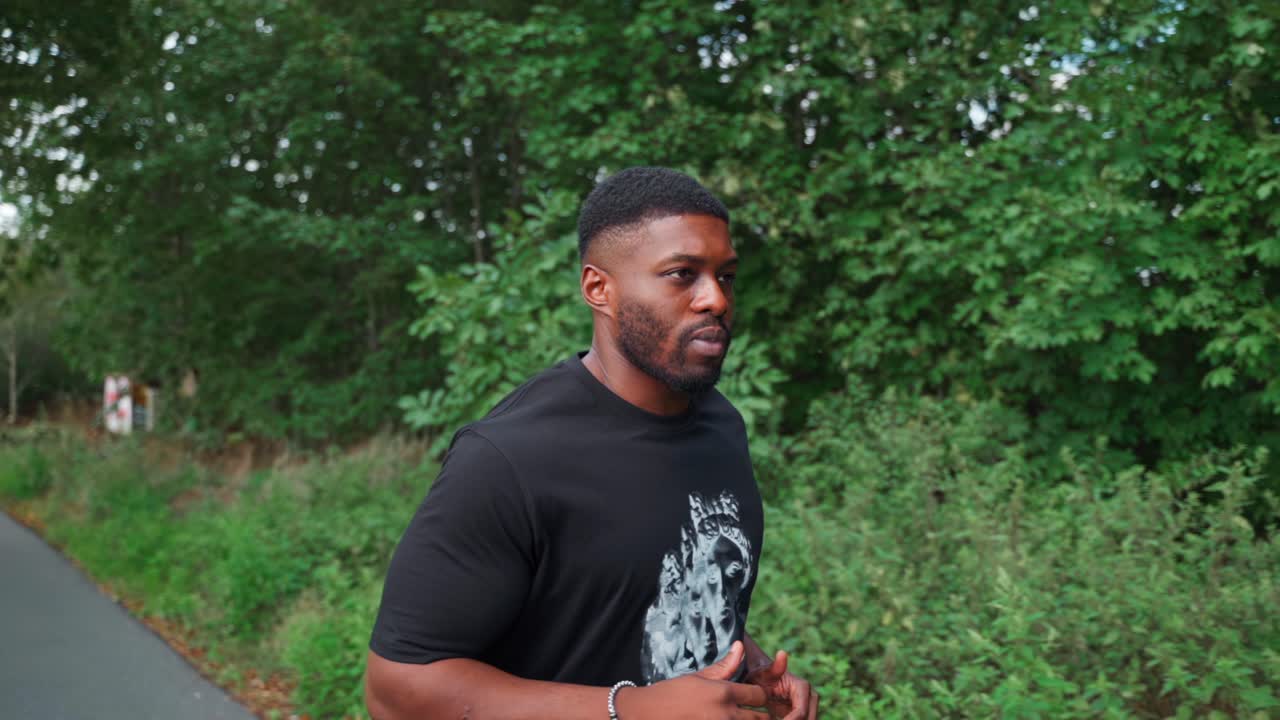 Uomo africano che corre in un parco al rallentatore.
