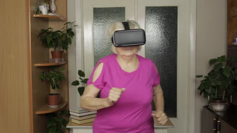 Ältere-Großmutter-Mit-Virtueller-Headset-Brille,-Die-Sich-3D-Videos-Im-VR-Helm-Ansieht-Und-Zu-Hause-Läuft