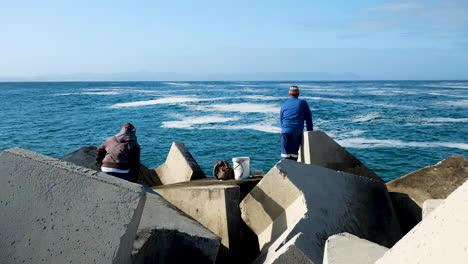 Local-fishermen-standing-on-dolosse-of-harbour-to-try-and-catch-a-fish