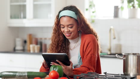 mujer siguiendo una receta en su tableta en una cocina