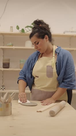 mujer trabajando con arcilla en el estudio de cerámica