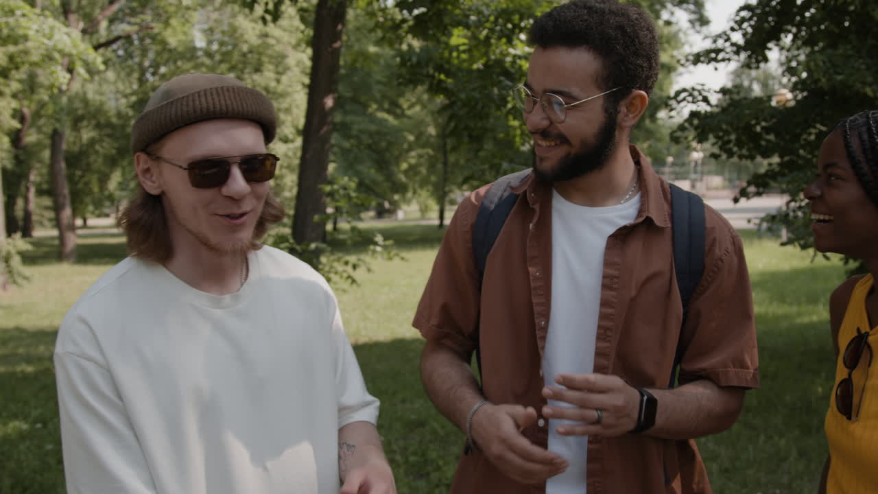 Diverse group of friends enjoying a conversation and laughing in a park