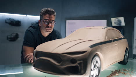 car designer examining clay model