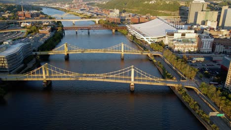 aerial drone view over bridges on the river, golden hour in pittsburgh, usa